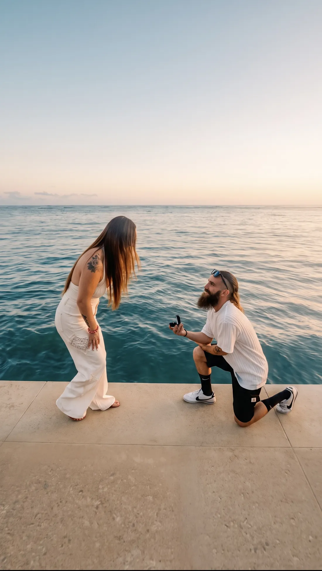 Gage on one knee at sunset on the Waikīkī seawall