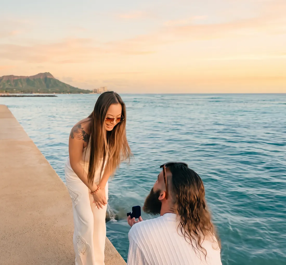 Megan smiling as Gage opens the ring box, Diamond Head behind